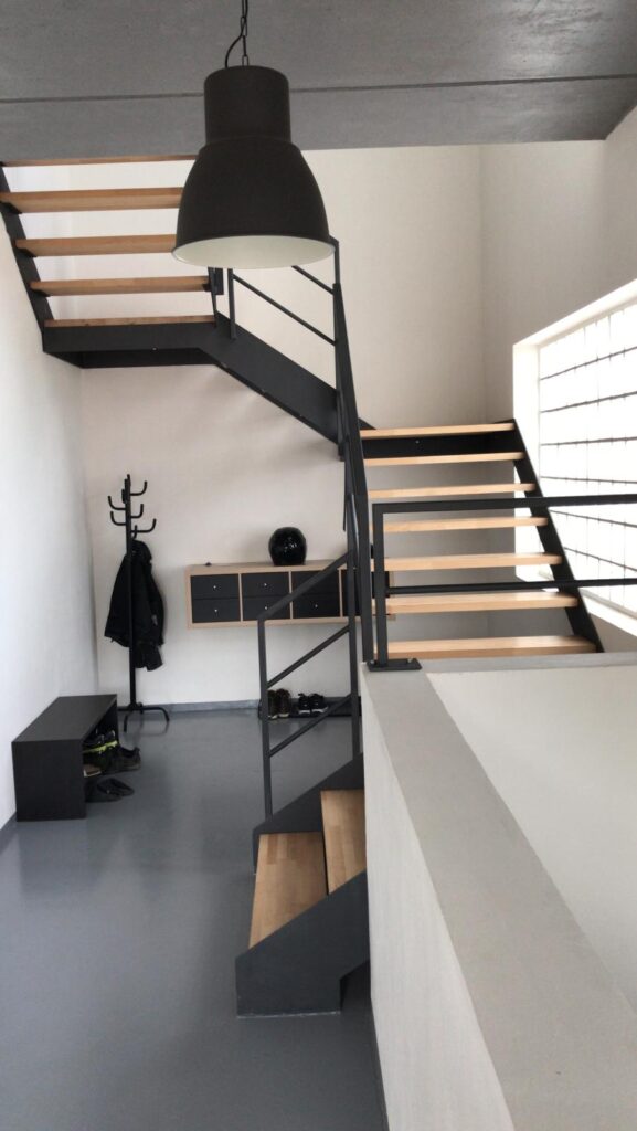 Interiérové ocelové schodiště s otevřenými stupni a dřevěnými nášlapy (Minimalistická konstrukce, vizuálně lehká. Industriální základ, ale díky dřevu nepůsobí studeně.)