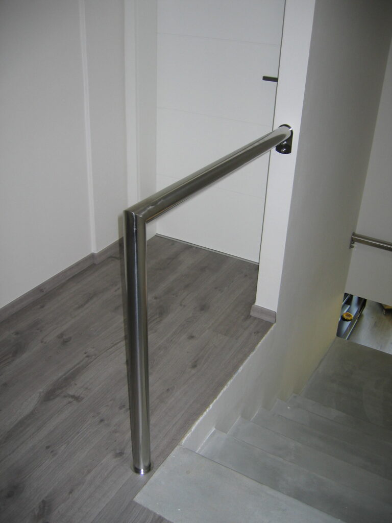 mimimalistické nerezové schodišťové madlo kotvené do stěny a podlahy